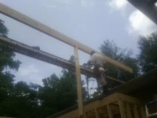 Carpenter setting a ridge beam over a new addition frame — Ice Dam Removal by Roofing Brothers in South Chatham