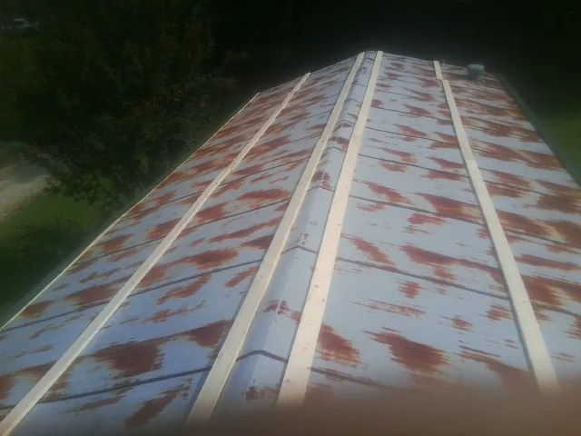 Rusted metal roof panels with new wood purlins before replacement — Storm Damage Roof Repair in South Chatham by Roofing Brothers