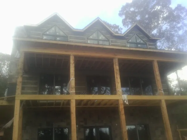 Dormers and porch framing on a large log home under construction — Roof Coating work by our crew in South Chatham