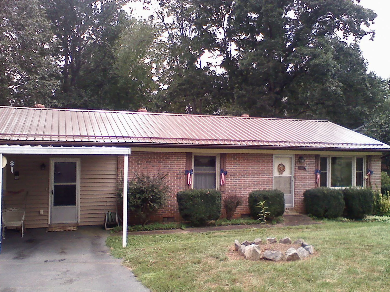 Bronze metal roof and carport on a brick ranch home — Roof Repair work by our crew in South Chatham